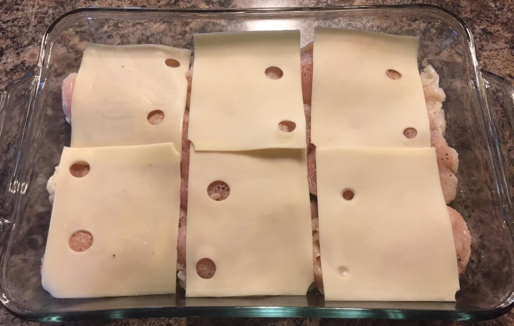 Layer the Swiss cheese slices over the chicken.